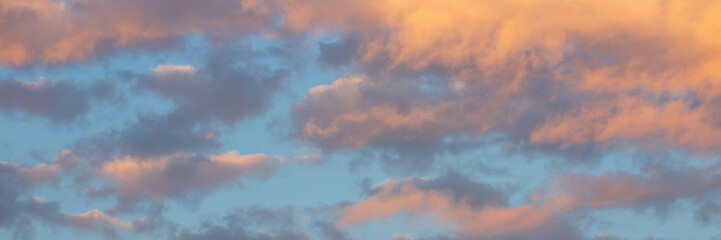 Beautiful sunset sky background with clouds. Scenic cloudscape. Wide panoramic background for design.