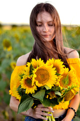 young long-haired girl in a field with sunflowers