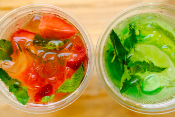 lemonades in plastic glasses. Takeaway drinks. Red and green cocktails