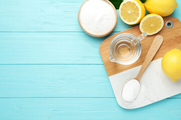 Baking soda, vinegar and cut lemons on light blue wooden table, flat lay. Space for text