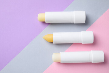 Hygienic lipsticks on color background, flat lay. Space for text