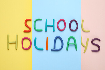 Phrase School Holidays made of modeling clay on color background, top view
