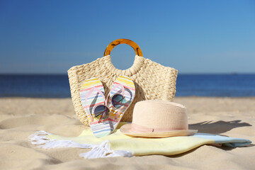 Stylish beach accessories for summer vacation on sand near sea