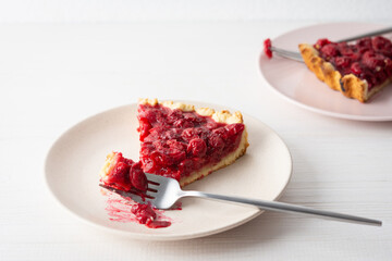 Cherry clafoutis on white background, plates with a portion of the pie and spoons