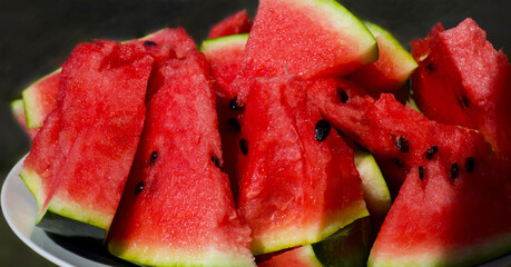  Slices of juicy watermelon on a white plate. Banner.