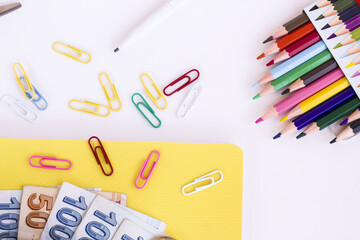 Colorful school supplies on white surface with calculator and Turkish money.Conceptual image of school expenses
