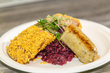 Delicious potato dumplings with fried meat with on red cabbage  on the plate. The food in the restaurant. Food styling and restaurant meal serving.