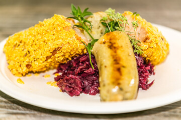 Delicious potato dumplings with fried meat with on red cabbage  on the plate. The food in the restaurant. Food styling and restaurant meal serving.