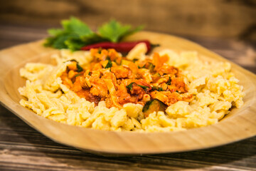Delicious gnocchi with meat and mushroom sauce  on the wooden plate. The food in the restaurant. Food styling and restaurant meal serving.