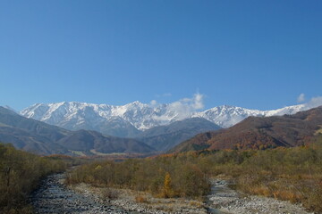 autumn landscape with snow covered mountains in Japanese alps