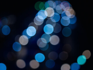 Abstract bokeh night light background, blurred lights traces from cars on road, defocused city traffic on street at night