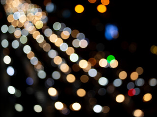 Abstract bokeh night light background, blurred lights traces from cars on road, defocused city traffic on street at night