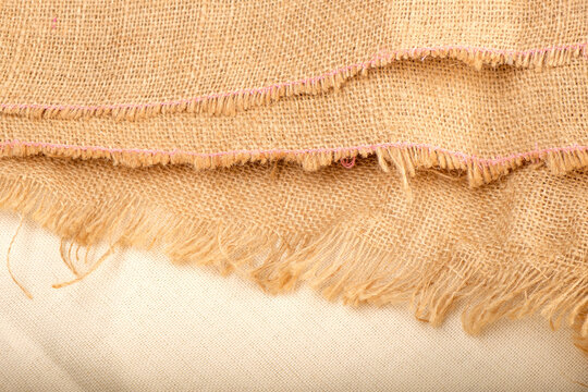 raw edge of linen fabric with threads sticking out in different directions