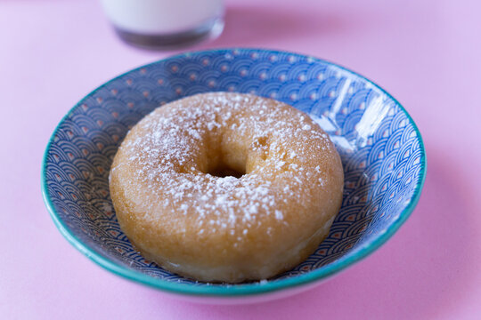 Delicious sugar doughnut against pink background