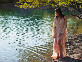 young female close to the lake during sunset