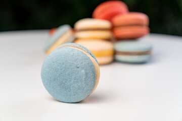 multicolored macarons from natural ingredients and colors on white table.