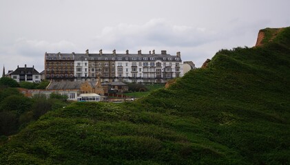 Fototapeta na wymiar Landscape showing grassy hills and a row of terrace houses in Saltburn-by-the-Sea, Yorkshire, England