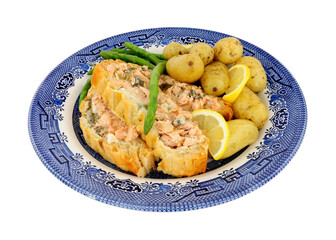 Sliced puff pastry covered salmon Wellington meal with new potatoes and asparagus isolated on a white background