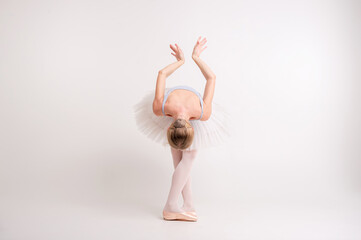 Young beautiful ballerina dances in big studio isolated on white background © benevolente