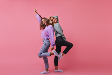 Full-length photo of inspired girls funny dancing together. Indoor shot of cheerful best friends...