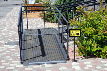 A ramp and a staff call button for access to the store for people with disabilities