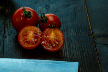 still life with fresh red, green and yellow tomatoes freshly picked from the garden on the wooden table and knife