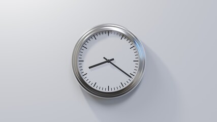 Glossy chrome clock on a white wall at twenty-one past eight. Time is 08:21 or 20:21