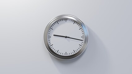 Glossy chrome clock on a white wall at seventeen past nine. Time is 09:17 or 21:17