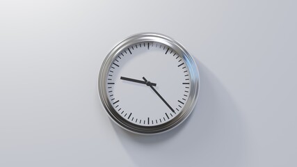 Glossy chrome clock on a white wall at twenty-three past nine. Time is 09:23 or 21:23