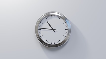 Glossy chrome clock on a white wall at forty-six past ten. Time is 10:46 or 22:46