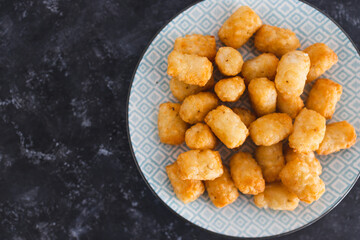 simple food ingredients, air fryed potato royals on small snack plate on dark background