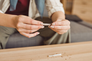 Warm-toned close up of unrecognizable adult woman taking marijuana for medicinal purposes in cancer recovery, copy space