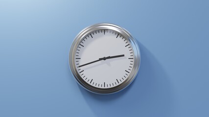 Glossy chrome clock on a blue wall at forty-two past two. Time is 02:42 or 14:42
