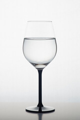 Wine glass with water on isolated white background. 
Gradient white grey background.