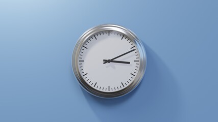 Glossy chrome clock on a blue wall at eleven past three. Time is 03:11 or 15:11