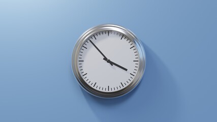 Glossy chrome clock on a blue wall at fifty-three past three. Time is 03:53 or 15:53