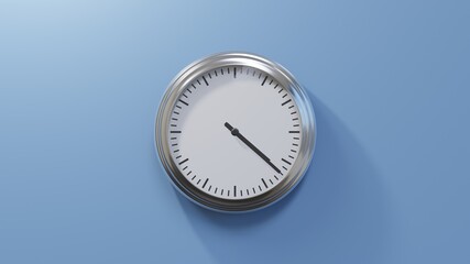 Glossy chrome clock on a blue wall at twenty-two past four. Time is 04:22 or 16:22