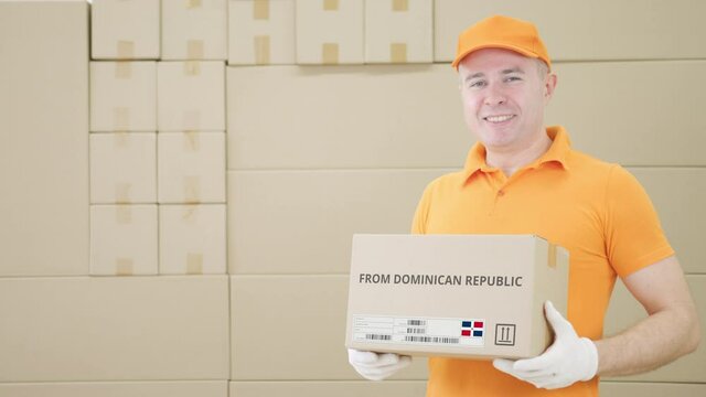 Warehouse worker holds parcel with FROM DOMINICAN REPUBLIC text on it