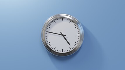 Glossy chrome clock on a blue wall at forty-seven past four. Time is 04:47 or 16:47