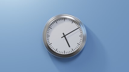 Glossy chrome clock on a blue wall at ten past five. Time is 05:10 or 17:10