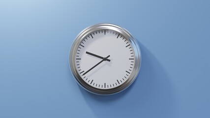 Glossy chrome clock on a blue wall at thirty-nine past nine. Time is 09:39 or 21:39