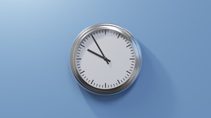 Glossy chrome clock on a blue wall at five to ten. Time is 09:55 or 21:55