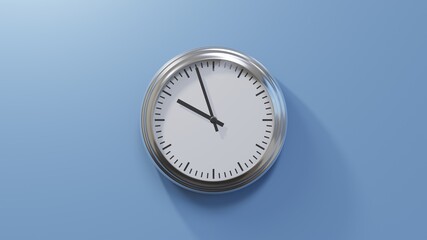 Glossy chrome clock on a blue wall at fifty-seven past nine. Time is 09:57 or 21:57