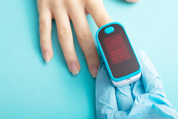 Saturation of hemoglobin of blood with oxygen. Doctor measures with a special medical device on a...