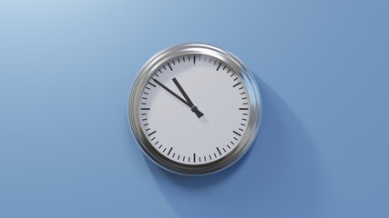 Glossy chrome clock on a blue wall at fifty-one past ten. Time is 10:51 or 22:51