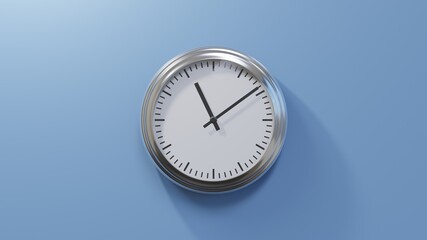 Glossy chrome clock on a blue wall at nine past eleven. Time is 11:09 or 23:09