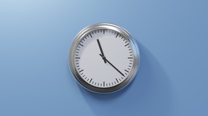 Glossy chrome clock on a blue wall at twenty-two past eleven. Time is 11:22 or 23:22