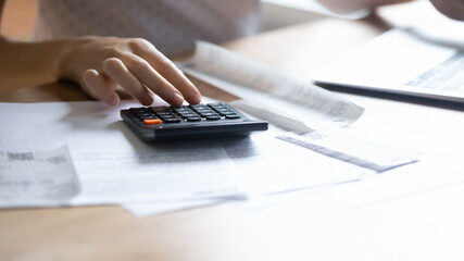 Crop close up of woman busy managing household expenditures family budget calculate finances on...