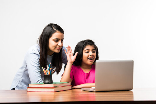 Indian / Asian Little Girl Studying Using Her Laptop Or Attending Online School At Home With Mother