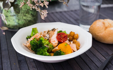 delicious warm salad of trout, chickpea, broccoli fillet in white vintage bowl